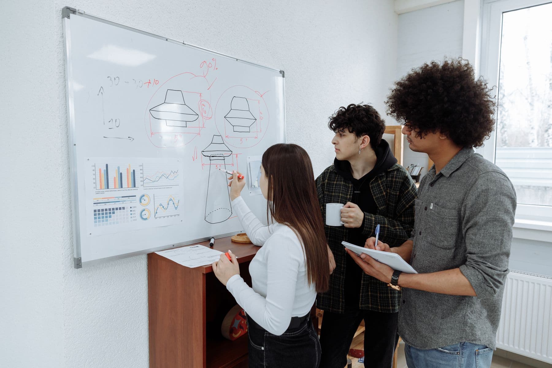 Colleagues organizing ideas on a whiteboard during a product planning workshop.