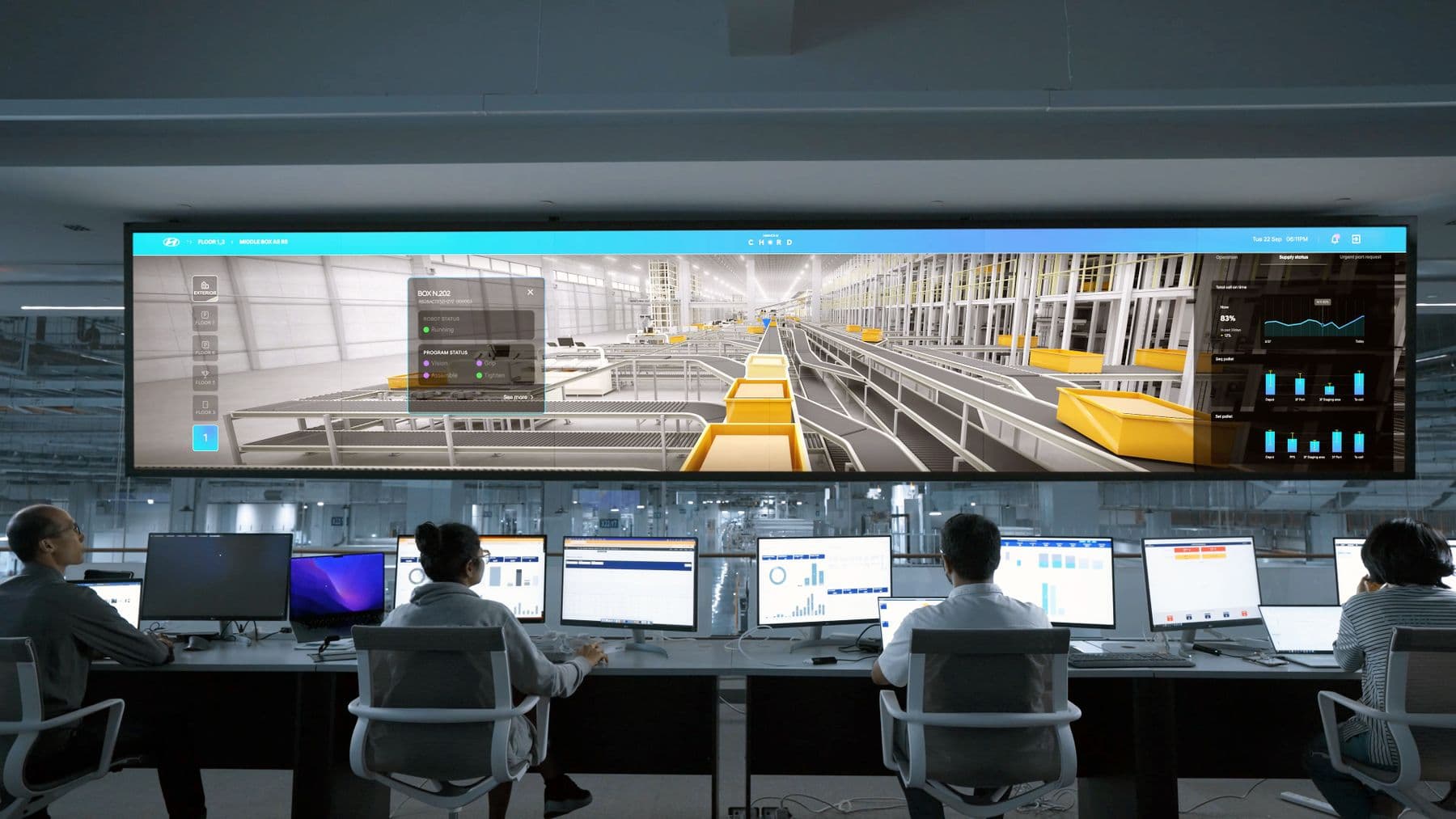Team working at computers with a large shared screen in a digital operations workspace.
